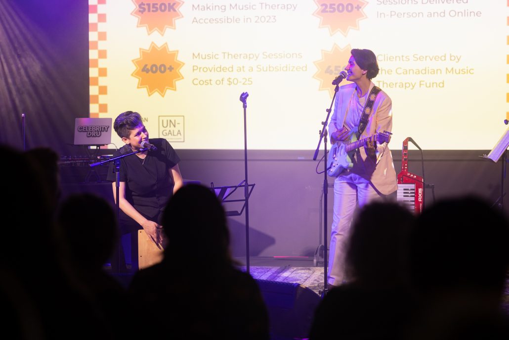 Performers and Music Therapists Reenie Perkovic and Trish MacAulay singing together and looking at each other on stage, Un-Gala 2024